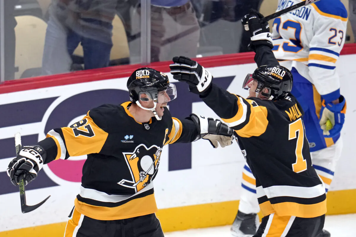 Pittsburgh Penguins' Sidney Crosby (87) celebrates his game-winning goal in overtime with Evgeni Malkin during an NHL hockey game against the Buffalo Sabres in Pittsburgh on Oct. 16, 2024. (Gene Puskar/AP Photo)