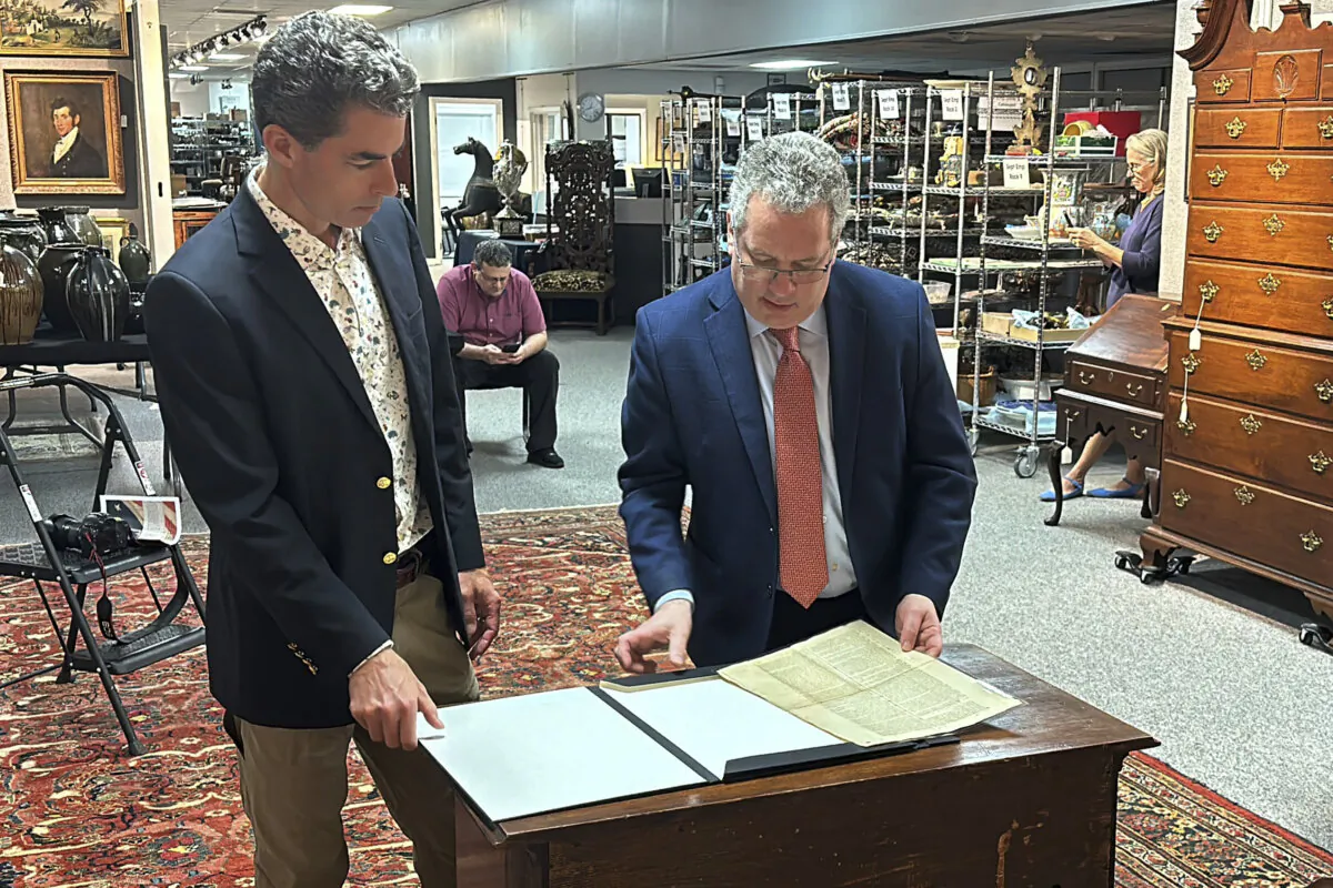 Auctioneer Andrew Brunk, (L), and historian Seth Kaller, right show off a 1787 copy of the U.S. Constitution that will be put up for auction at Brunk Auctions in Asheville, N.C., on Sept. 5, 2024. (Jeffrey Collins/AP Photo)