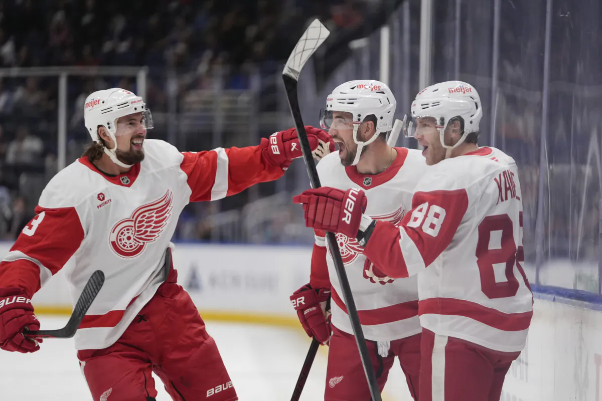 Detroit Red Wings' Patrick Kane (88) celebrates with Erik Gustafsso and Justin Holl (3) after scoring a goal during the first period of an NHL hockey game against the New York Islanders in Elmont, N.Y., on Oct. 22, 2024.(Frank Franklin II/AP Photo)