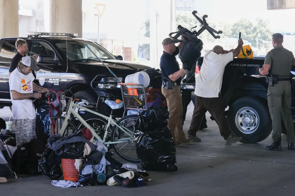Louisiana Wildlife and Fisheries agents assist state police as they give instructions to people living in a homeless encampment to move to a different pre-designated location as they perform a sweep in advance of a Taylor Swift concert in New Orleans, Wednesday, Oct. 23, 2024. (Gerald Herbert/AP Photo)