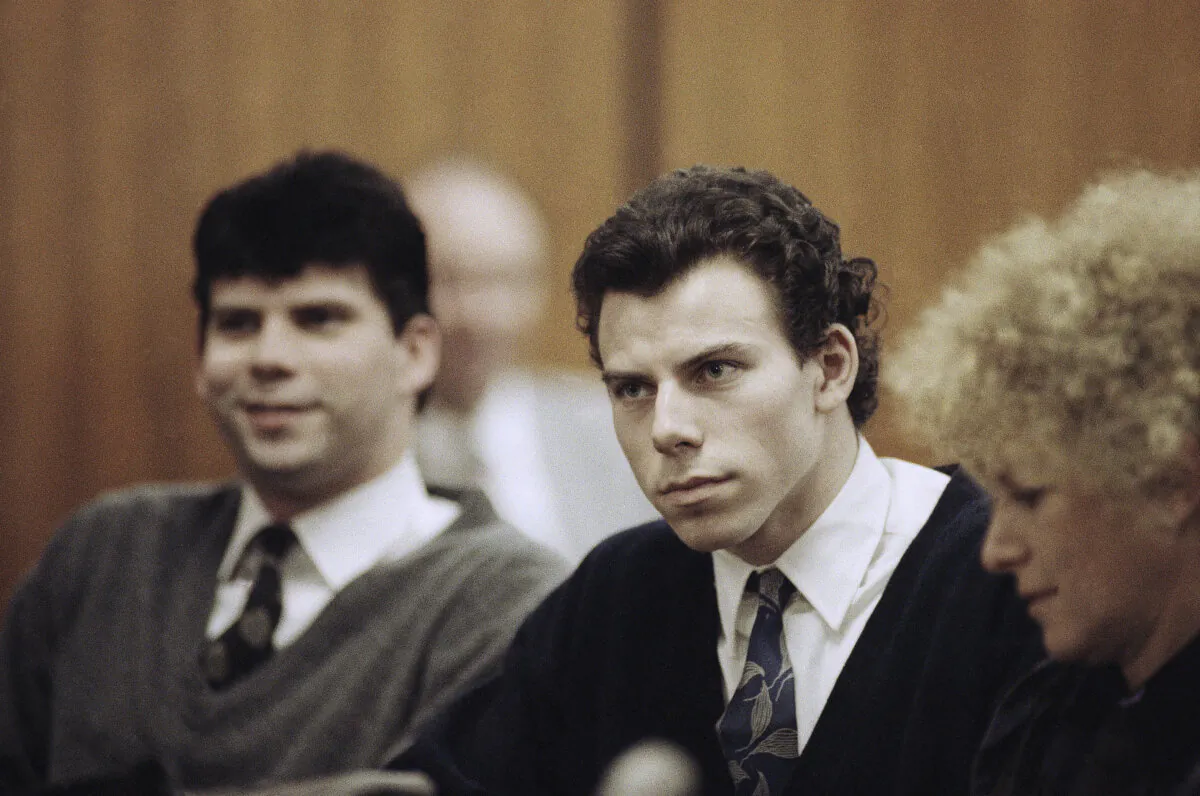 Lyle (L) and Erik Menendez sit with defense attorney Leslie Abramson (R) in Beverly Hills Municipal Court during a hearing on Nov. 26, 1990. (Nick Ut/AP Photo)