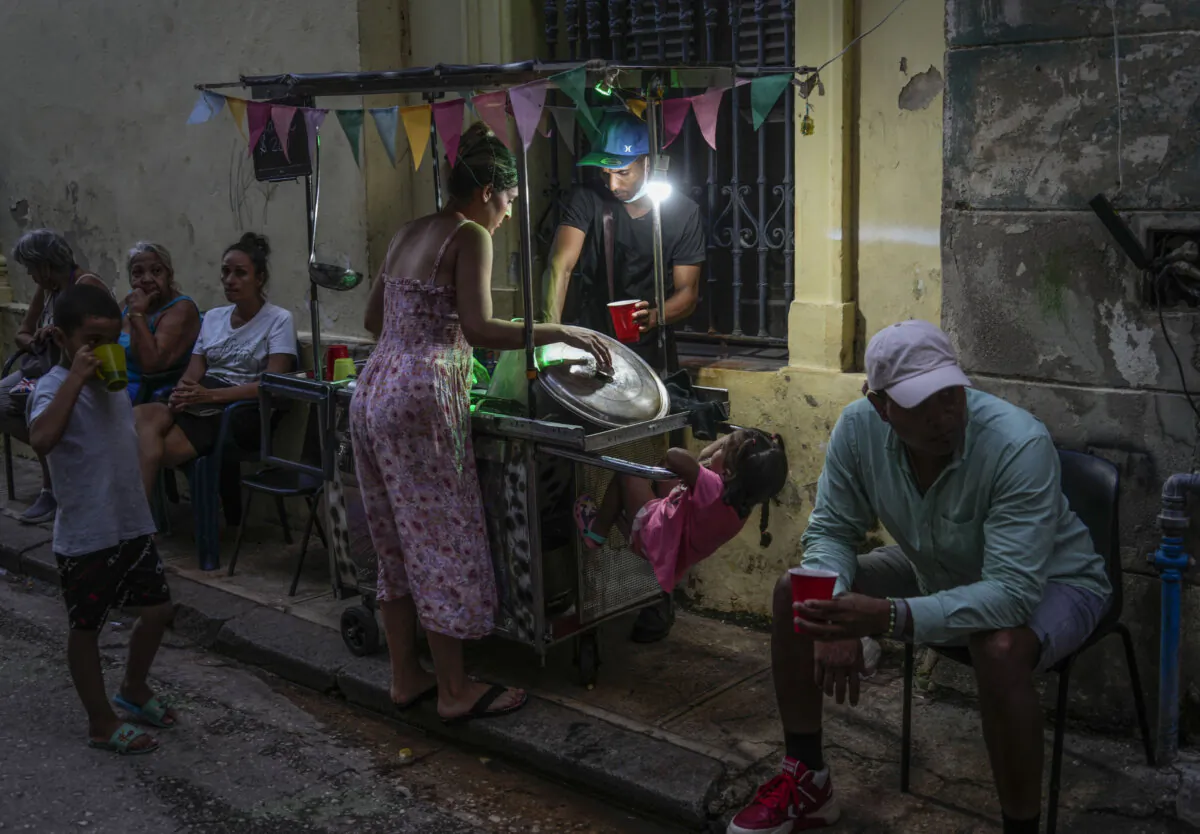 A woman buys soup from a street vendor during a power outage in Havana, Monday, Oct. 21, 2024. (Ramon Espinosa/AP Photo)