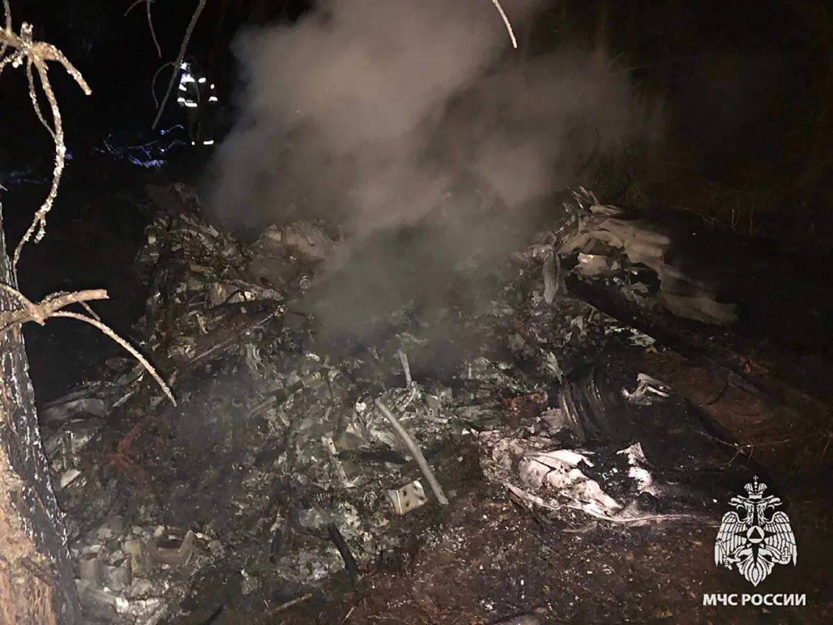 In this photo released by Russian Emergency Ministry Press Service on Saturday, Oct. 26, 2024, debris of an ambulance helicopter that made a hard landing are seen in a forest near the Beleenki village in the Kirov region of Russia. (Russian Emergency Ministry Press Service via AP)