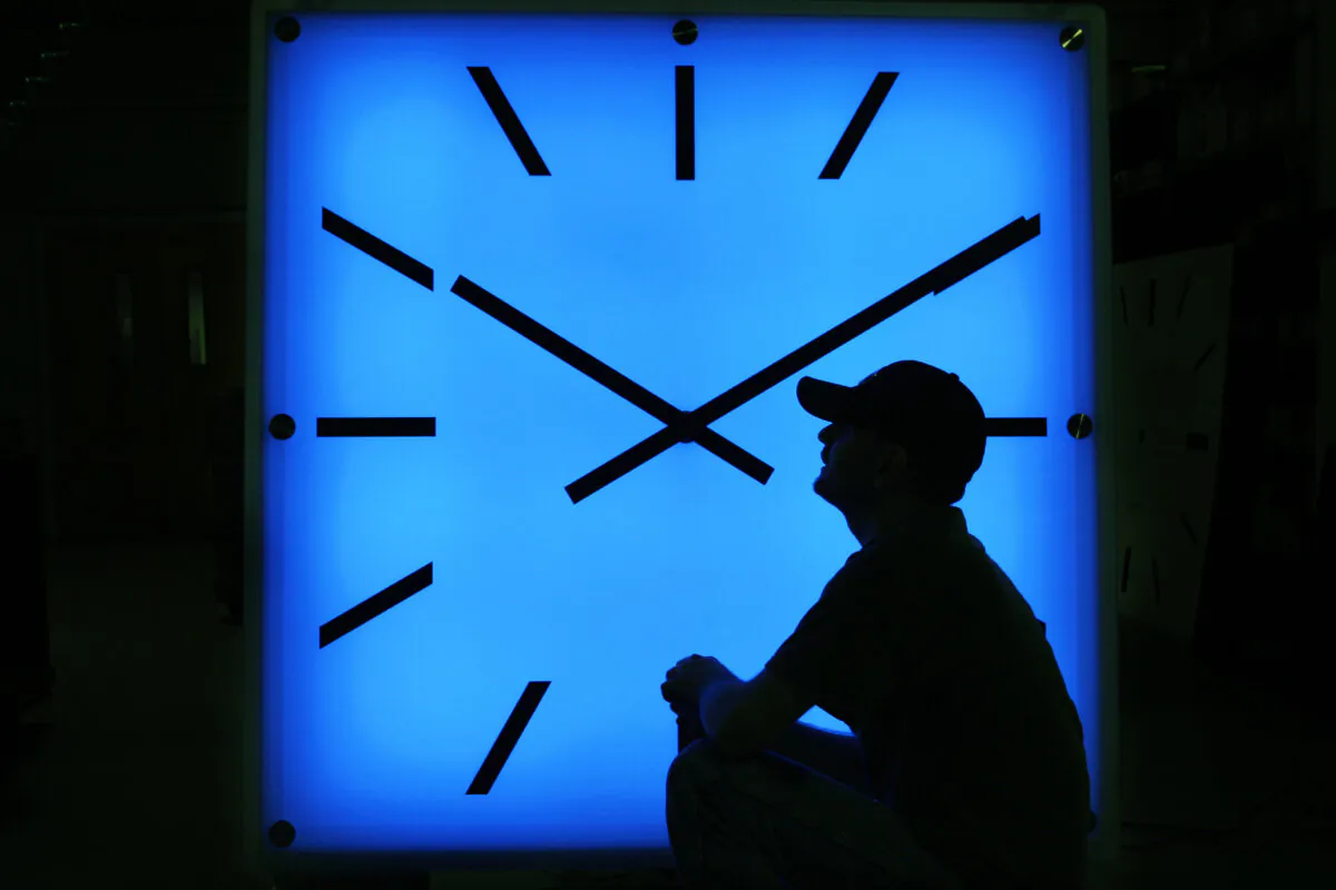 An Electric Time Company employee adjusts the color on a clock at the plant in Medfield, Mass., on Oct. 30, 2008, days before the switch to standard time. (Elise Amendola/AP Photo)