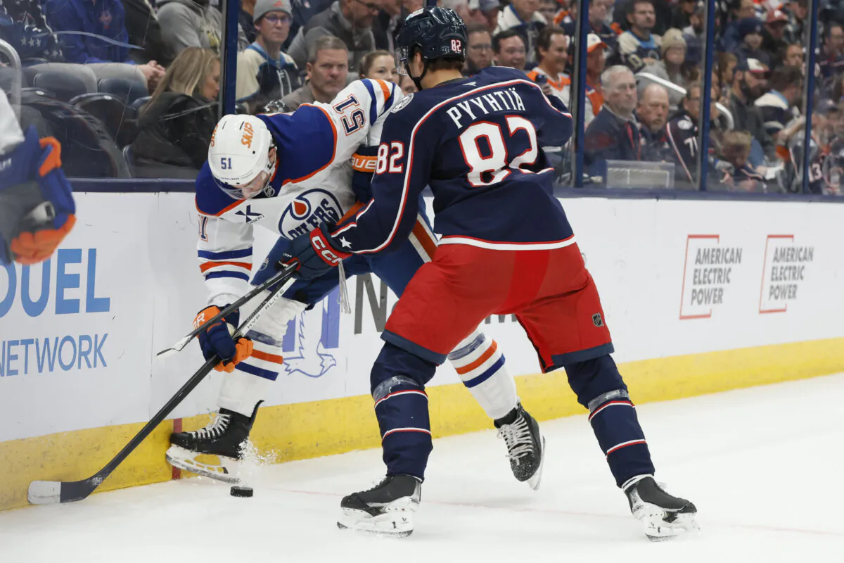 Edmonton Oilers' Troy Stecher, left, and Columbus Blue Jackets' Mikael Pyyhtia fight for the puck during the second period of an NHL hockey game in Columbus, Ohio, on Oct. 28, 2024. (Jay LaPrete/AP Photo)