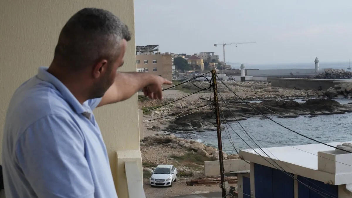 A Lebanese man points to the beach in Batroun, northern Lebanon, on Nov. 2, 2024, where Lebanese officials say a group of armed men landed on a coast north of Beirut and took away a ship captain and they're investigating whether Israel was involved. (Hussein Malla/AP Photo)