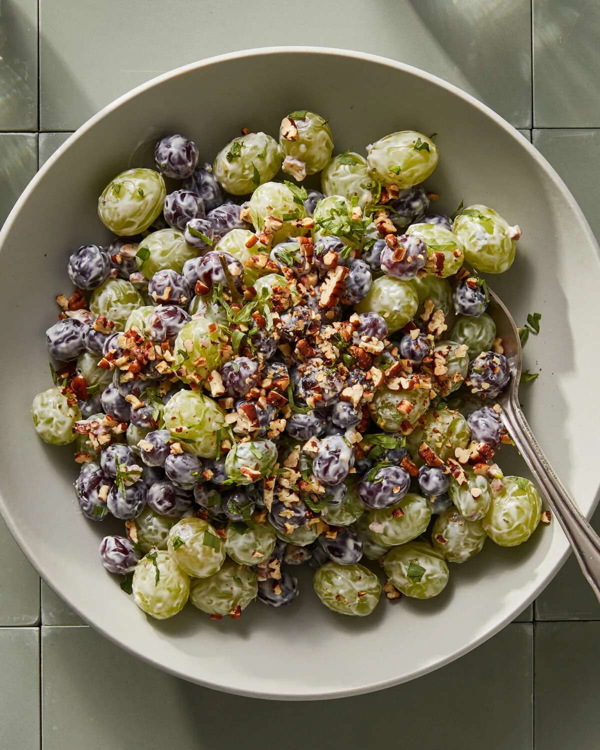 Enjoy grapes tossed in a sweetened cream cheese and sour cream sauce topped with toasted pecans and tarragon. (Chris Simpson/TCA)