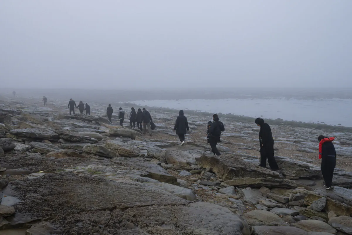 A group of Kurdish migrants from Iran and Iraq who failed in their attempt to reach the UK by boat walk back to the town of Ambleteuse in France on May 19, 2024. (Bernat Armangue/AP)
