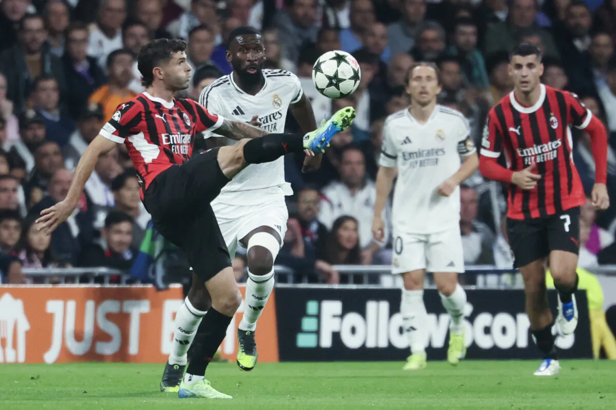 AC Milan's American forward #11 Christian Pulisic (L) is challenged by Real Madrid's German defender #22 Antonio Ruediger during the UEFA Champions League match between Real Madrid CF and AC Milan at the Santiago Bernabeu stadium in Madrid on Nov. 5. (Pierre-Philipe Marcou/AFP via Getty Images)