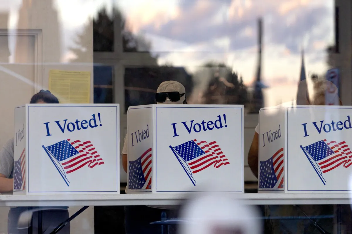 People complete their ballots as the sunset is reflected in the glass of a precinct in the Bloomfield neighborhood of Pittsburgh on Nov. 5, 2024. (Rebecca Droke/AFP via Getty Images)