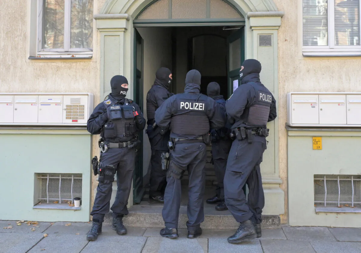 Masked German police officers guard a house after having arrested eight suspected members of a right-wing militant group who had been training in warfare for the downfall of the modern German state, in Dresden, Germany, on Nov. 5, 2024.  (Reuters/Matthias Rietschel) 
