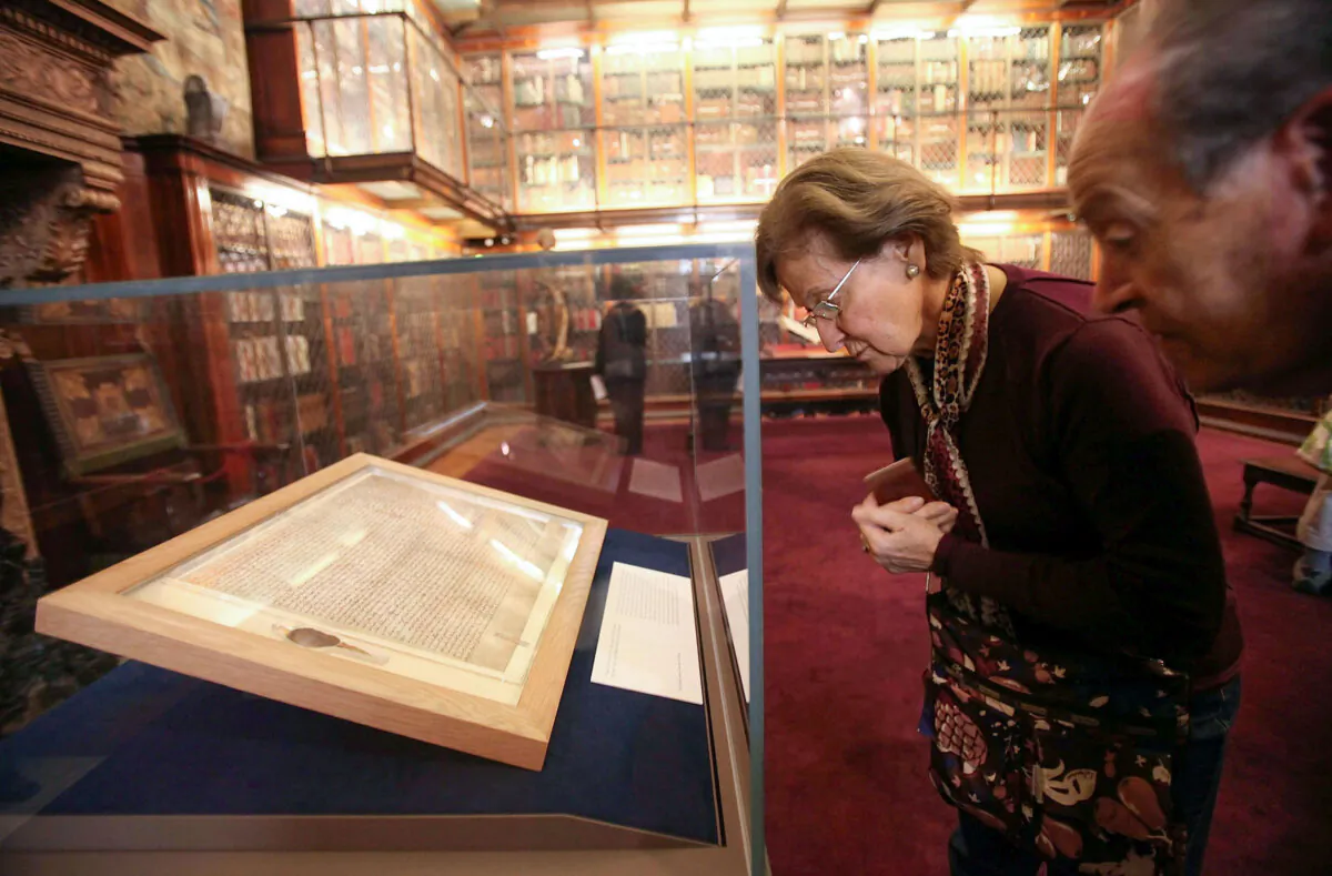 Visitors look at one of the earliest original manuscripts of the Magna Carta from 1217 at the Morgan Library & Museum in New York in a file photo. (Mario Tama/Getty Images)