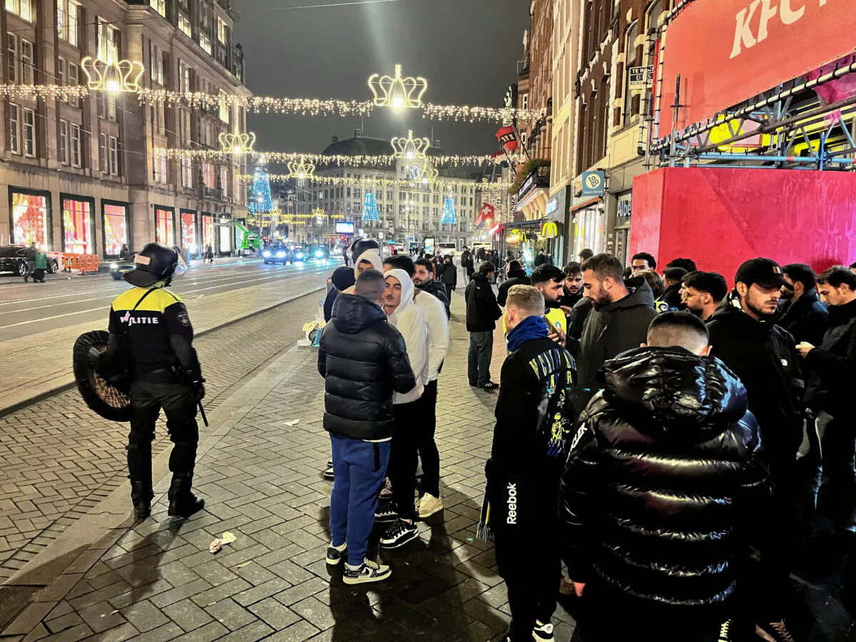 Israeli Maccabi Tel Aviv supporters are guarded by police after violence targeting Israeli soccer fans broke out in Amsterdam, Netherlands, overnight Nov. 8, 2024. (Ami Shooman/Israel Hayom via Reuters)