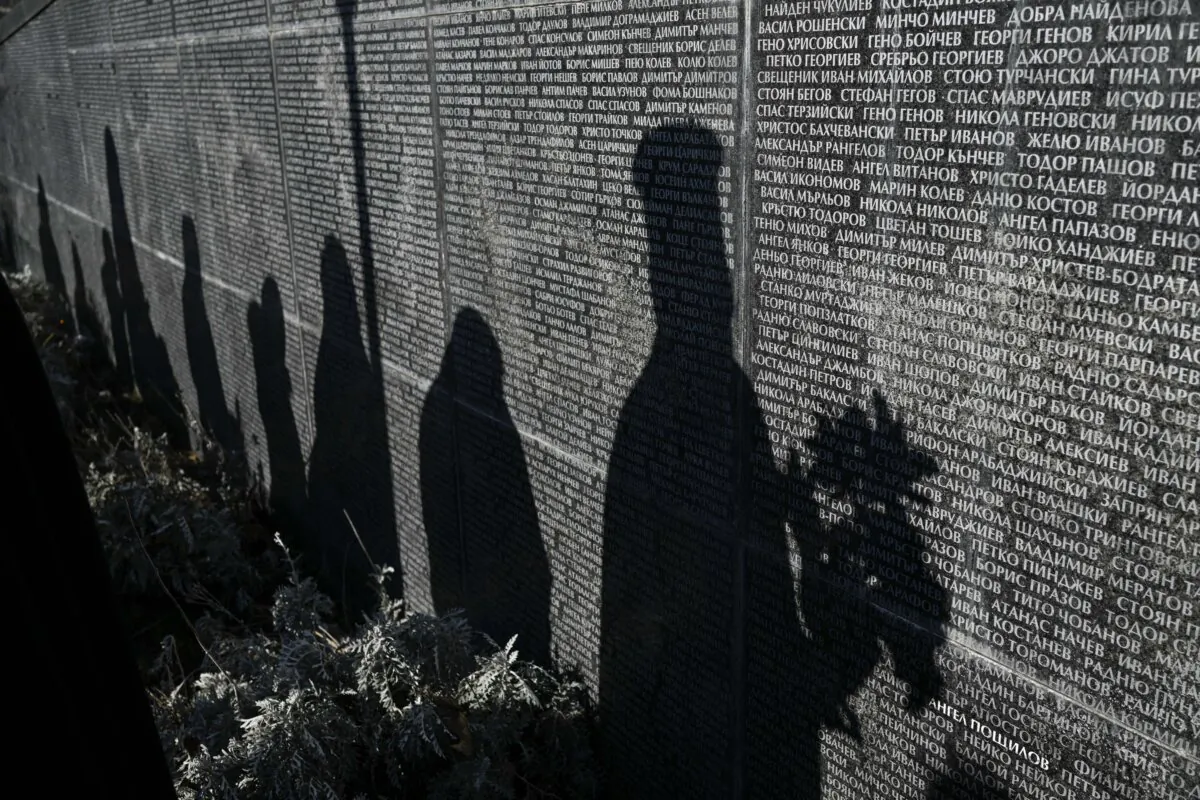 Shadows of people are seen on a monument listing victims of the communist regime in Bulgaria as they attend an open air mass in Sofia on Feb. 1, 2024. (Nikolay Doychinov/AFP via Getty Images)