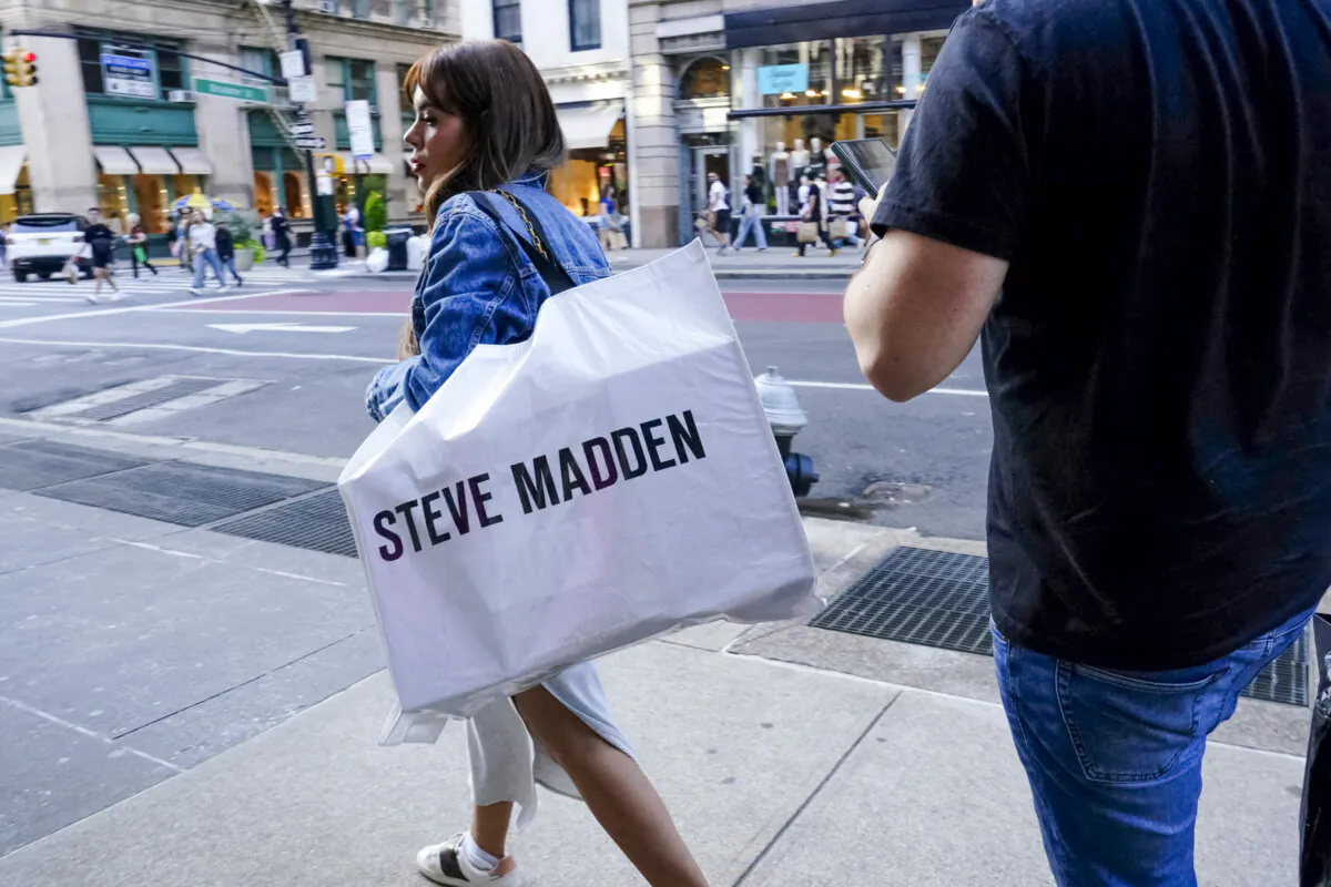 A woman carrying a Steve Madden shopping bag walks through the SoHo neighborhood of New York City, on Sept. 21, 2023. (Bing Guan/Reuters)