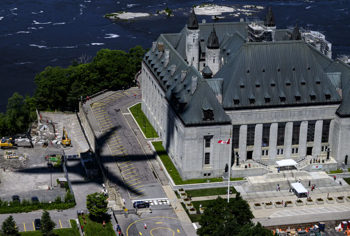 The shadow from a Royal Canadian Air Force CC-330 Husky is seen as it passes the Supreme Court of Canada, during a flypast celebrating the RCAF centennial, on Canada Day, on July 1, 2024. (The Canadian Press/Justin Tang)