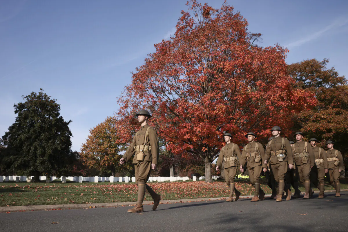 U.S. troops march during a joint full honors procession, some wearing uniforms from World War I, World War II, and the Korean War, in commemoration of the 100th anniversary of the Tomb of the Unknown Soldier on Veterans Day in Arlington National Cemetery in Virginia on Nov. 11, 2021. (Anna Moneymaker/Getty Images)