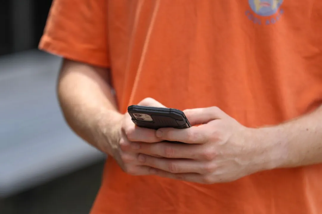 A man looks at his smartphone in Newcastle, Australia on Dec. 1, 2024. (Roni Bintang/Getty Images)