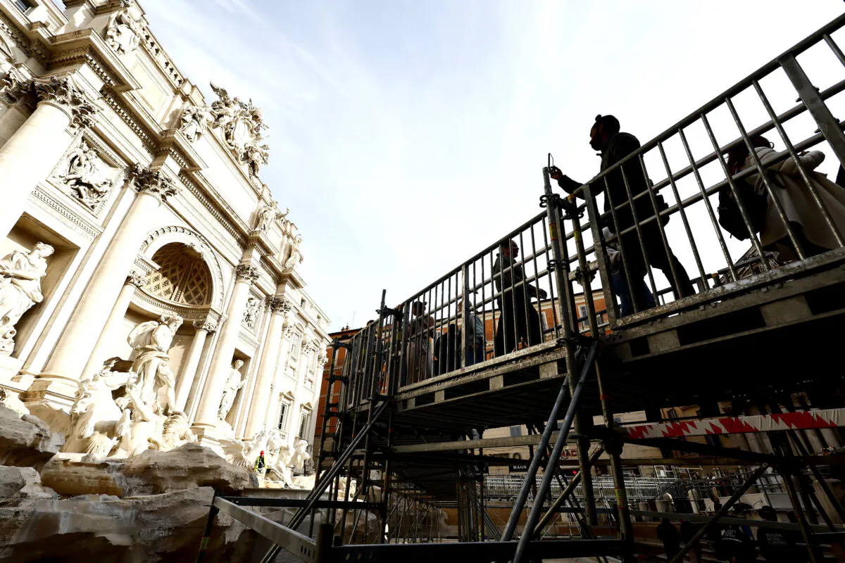 People walk along an elevated walkway that gives limited access to the Trevi Fountain monument during maintenance work in Rome on Nov. 9, 2024. (Cecilia Fabiano/LaPresse via AP)