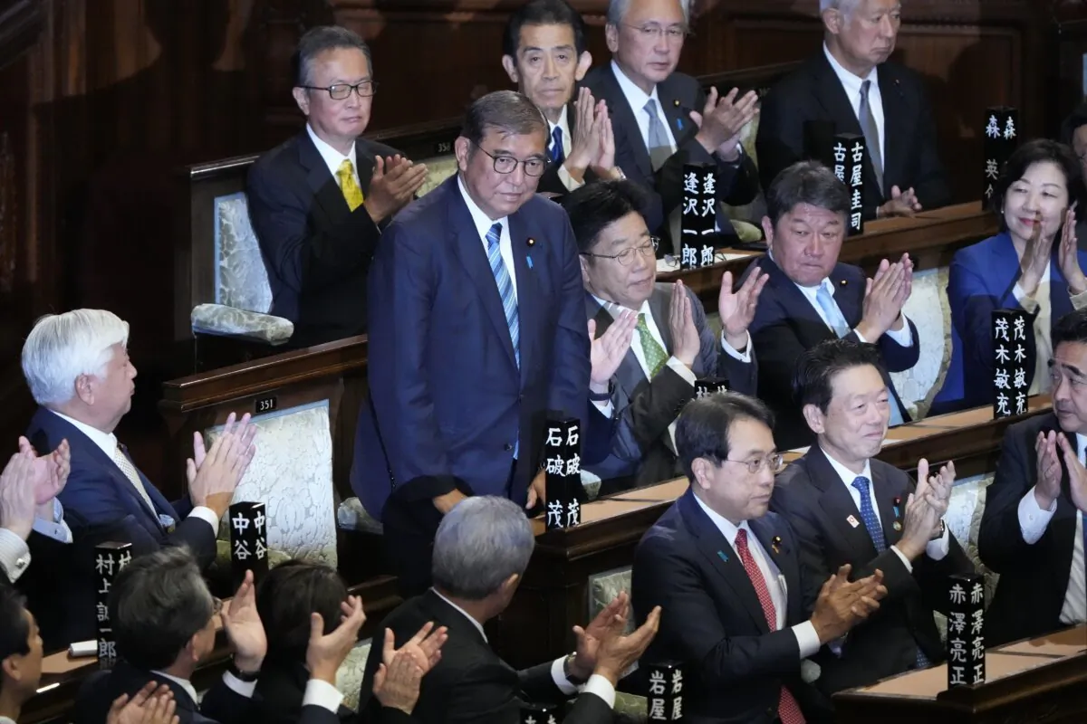 Japanese Prime Minister Shigeru Ishiba (standing) is applauded after winning a vote for a new prime minister at a special parliamentary session of the lower house in Tokyo on Nov. 11, 2024. (AP Photo/Eugene Hoshiko)