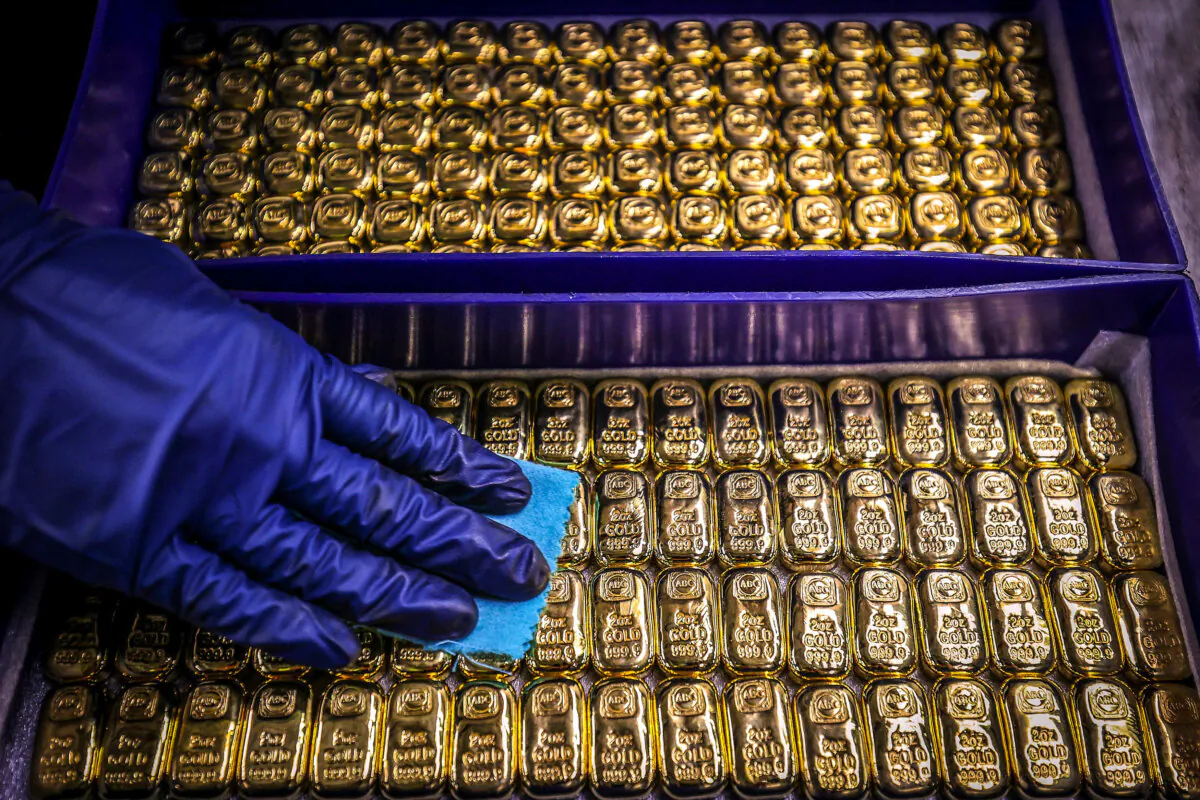 A worker polishes gold bullion bars at Australia's ABC Refinery in Sydney on Aug. 5, 2020. (David Gray/AFP via Getty Images)