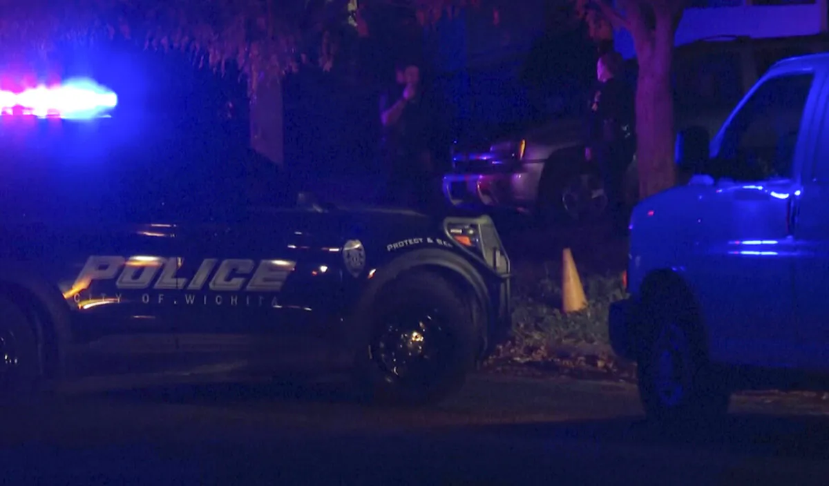 Police officers respond after multiple men were found shot to death inside several homes in the same area of Wichita, Kan., on Nov. 10, 2024. (KAKE via AP)