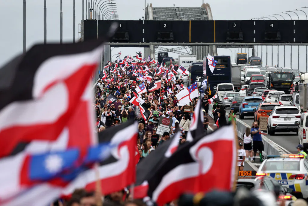 Hikoi (community march) members walk across the Auckland Harbour Bridge on day three of a nine-day journey to Wellington in New Zealand on Nov. 13, 2024. A hīkoi is traveling across New Zealand, with Māori communities marching to Wellington to protect and advocate for the interpretation of the Treaty of Waitangi and unique Māori rights. (Fiona Goodall/Getty Images)