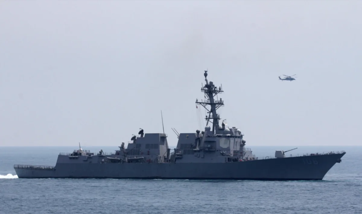 An MH-60S helicopter flies near the ear the guided-missile destroyer USS Stockdale (DDG 106) while transiting the Arabian Gulf, March 29, 2019. (U.S. Navy photo by Mass Communication Specialist 1st Class Ryan D. McLearnon)