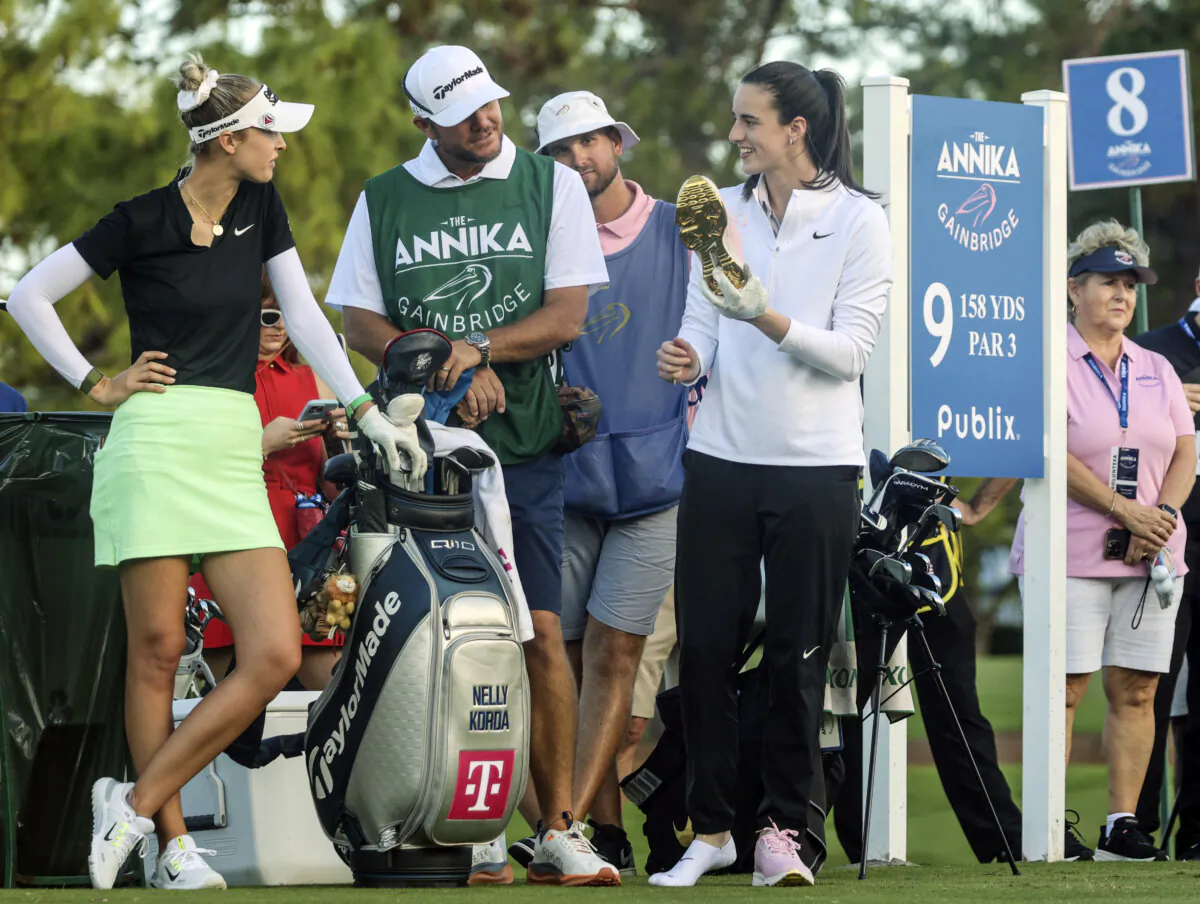 WNBA basketball player Caitlin Clark of the Indiana Fever shows her gold-soled Nike golf shoes to LPGA pro golfer Nelly Korda (L) at the ninth tee during the pro-am at the LPGA Tour golf tournament at the Pelican Golf Club in Belleair, Fla., on Nov 13, 2024. (Douglas R. Clifford/Tampa Bay Times via AP)