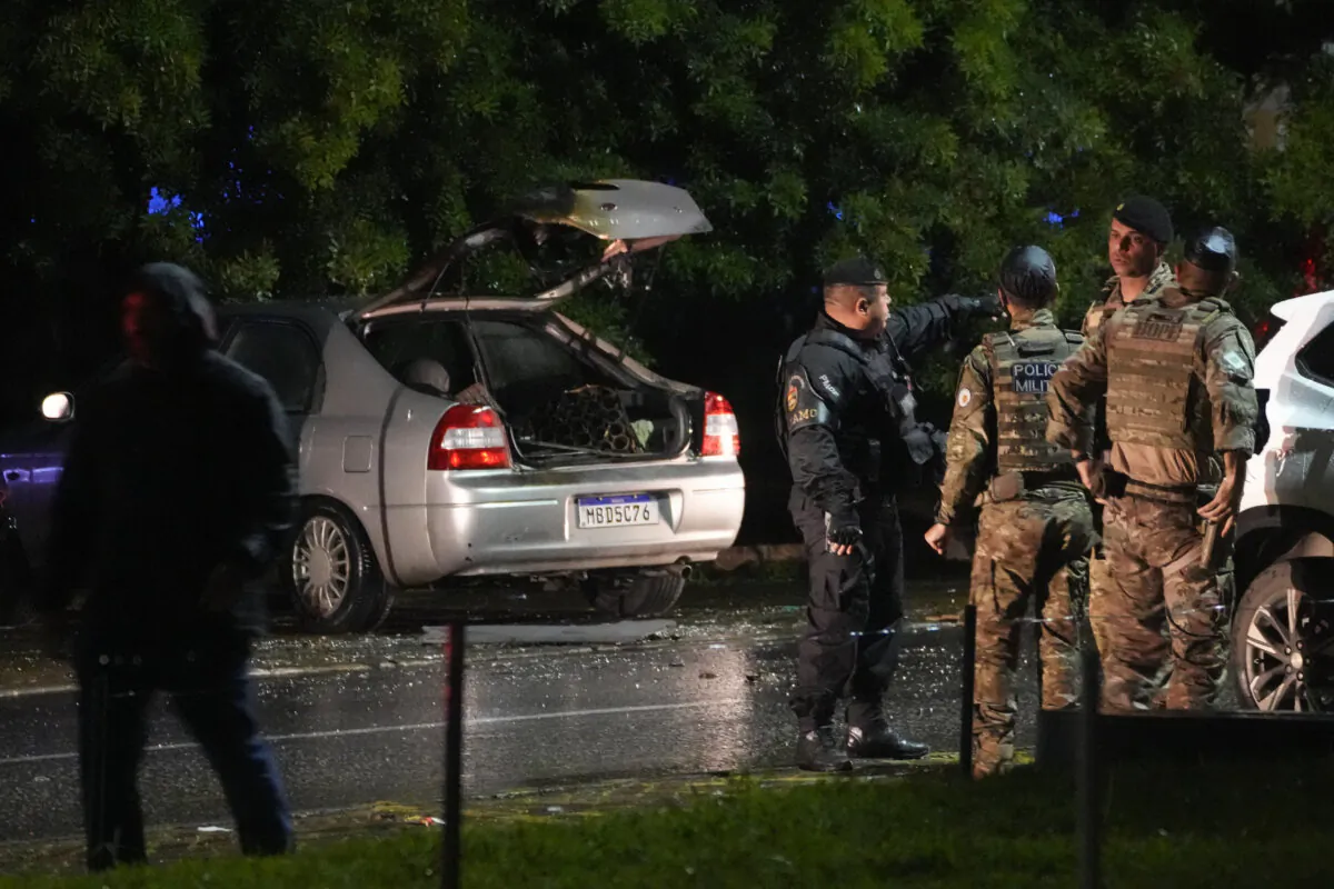 Police inspect a vehicle outside the Supreme Court in Brasília, Brazil, following an explosion on Nov. 13, 2024. (AP Photo/Eraldo Peres)