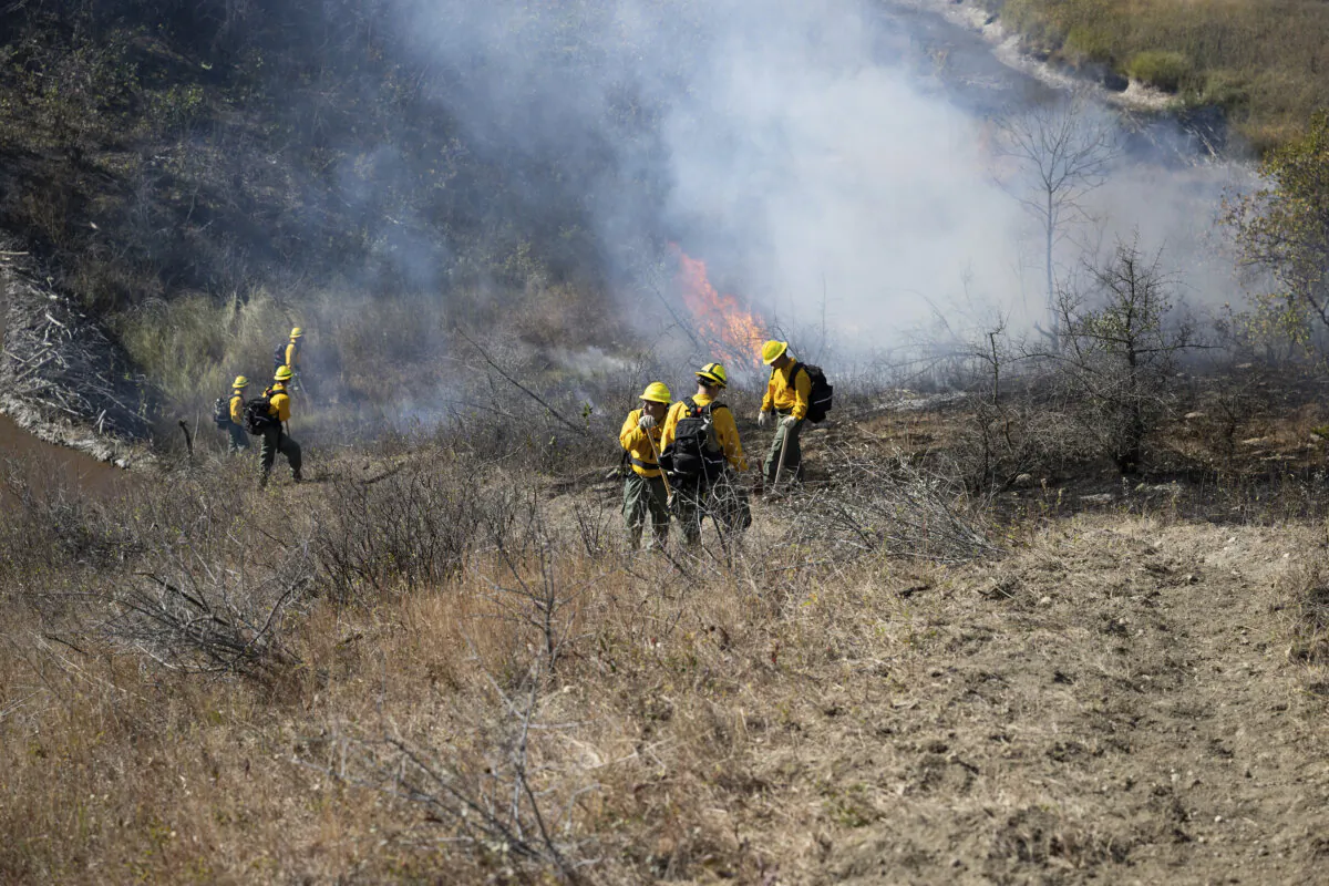 North Dakota National Guard soldiers and airmen work with the Department of Emergency Services to build a handline and conduct a controlled burn to prevent the further spread of a wildfire in Mandaree, N.D., on Oct. 6, 2024. (Staff Sgt. Samuel J. Kroll/U.S. Army National Guard via AP)
