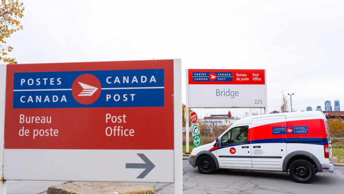 A Canada Post delivery truck leaves a depot in Montreal on Nov. 4, 2024. (The Canadian Press/Christinne Muschi)
