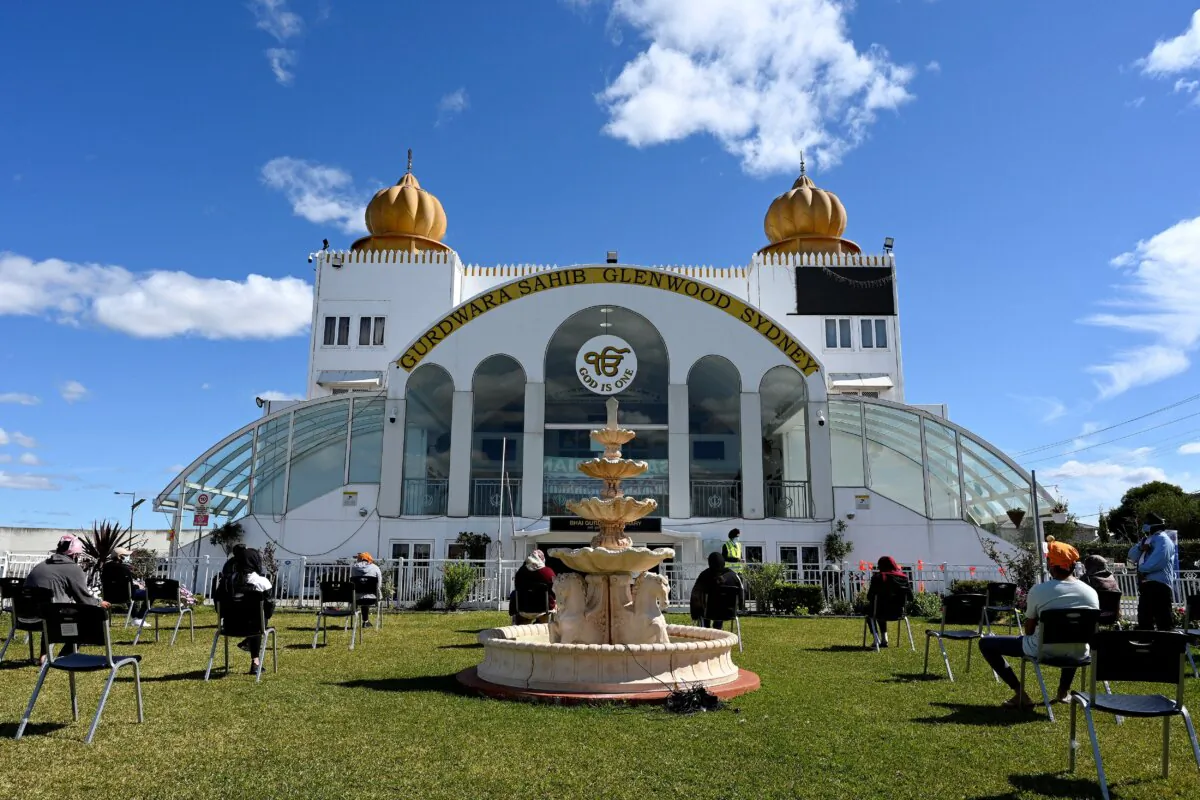 This picture taken on Aug. 26, 2021, shows members of the local Sikh community waiting outside a Glenwood Sikh Temple in Sydney, Australia. (Saeed Khan/AFP via Getty Images)