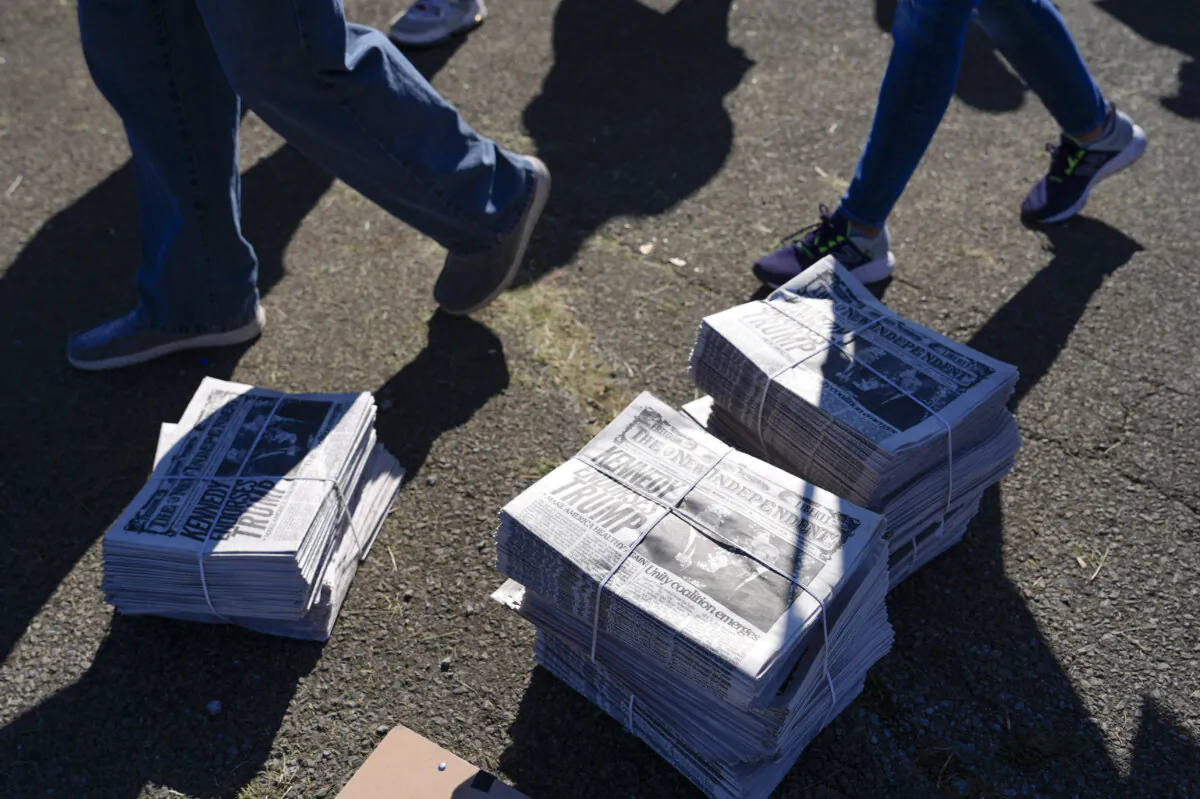 Stacks of newspapers sit on the ground as people arrive at a campaign rally held by Republican presidential nominee Donald Trump in Butler, Pa., on Oct. 5, 2024. (AP Photo/Julia Demaree Nikhinson) 