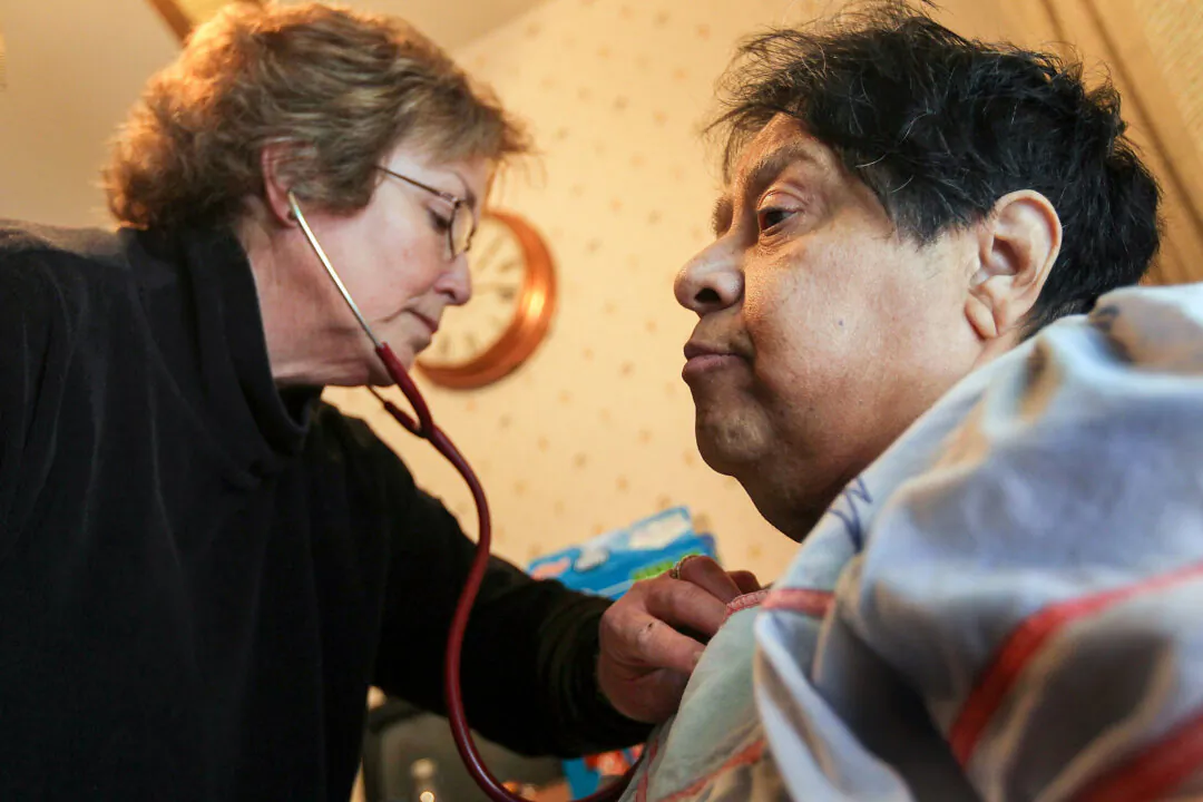  registered nurse checks the breathing of a patient who suffers from severe diabetes, while performing a home health care visit in Thornton, Colorado, on Feb. 24, 2010. (John Moore/Getty Images)