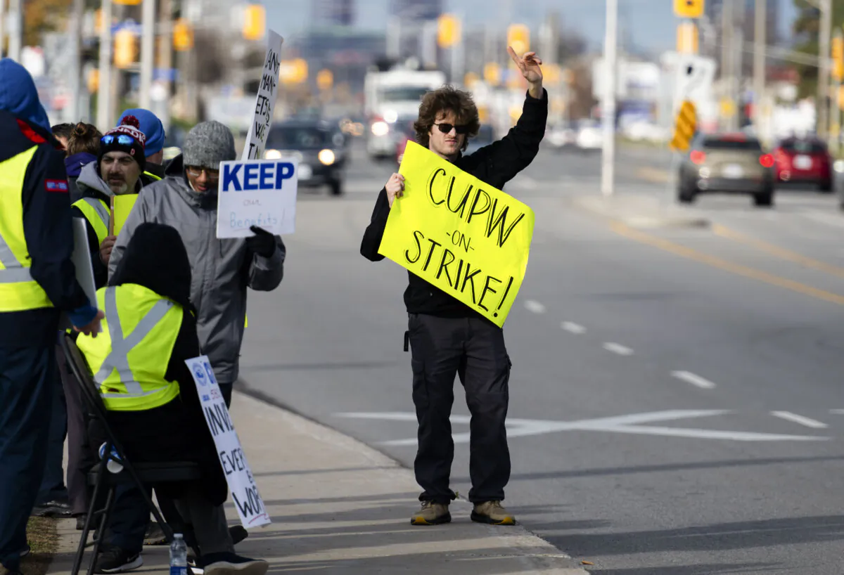 Canada Post employees picket outside a mail-sorting facility during nationwide strike action in Ottawa on Nov. 18, 2024. (The Canadian Press/Spencer Colby) 