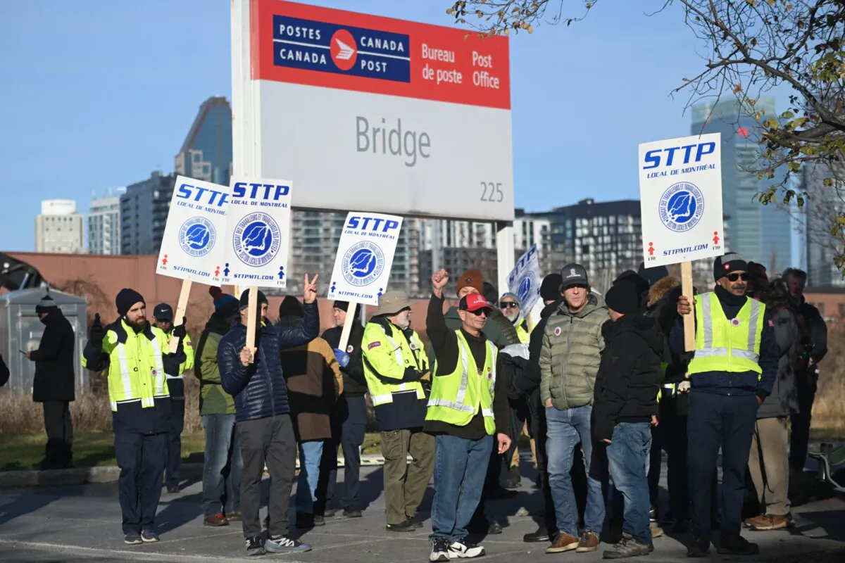 Canada Post workers picket outside a sorting plant in Montreal on Nov. 15, 2024. (The Canadian Press/Graham Hughes)