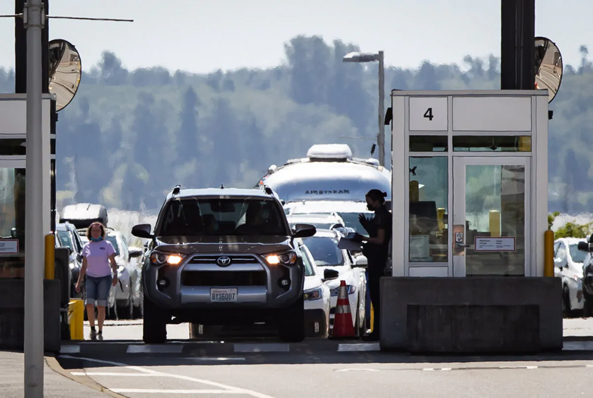 A CBSA officer speaks to a motorist entering Canada at the Douglas-Peace Arch border crossing, in Surrey, B.C., on Aug. 9, 2021.  (The Canadian Press/Darryl Dyck)