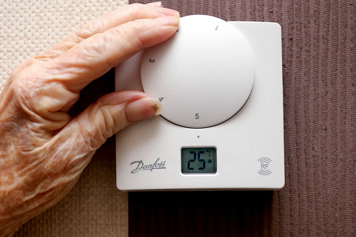 An elderly woman adjusting her thermostat at home in Liverpool, England, on Nov. 19, 2014. (Peter Byrne/PA Wire)