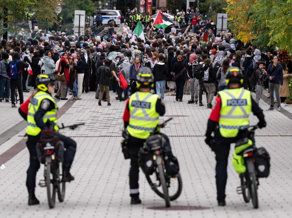 File photo shows police watching as people march near McGill University campus during a pro-Palestinian demonstration in Montreal on Oct. 7, 2024. (The Canadian Press/Christinne Muschi)