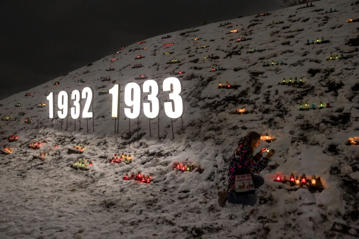 A woman lights a candle placed in a lantern in tribute to the victims of communism in the 1932–33 famine in Ukraine, at the National Museum of the Holodomor-Genocide in Kyiv on Nov. 23, 2024. Ukraine marked 91 years since the Holodomor famine inflicted by the Soviet regime under Stalin, which left millions dead. (Photo by Roman Pilipey/AFP via Getty Images)