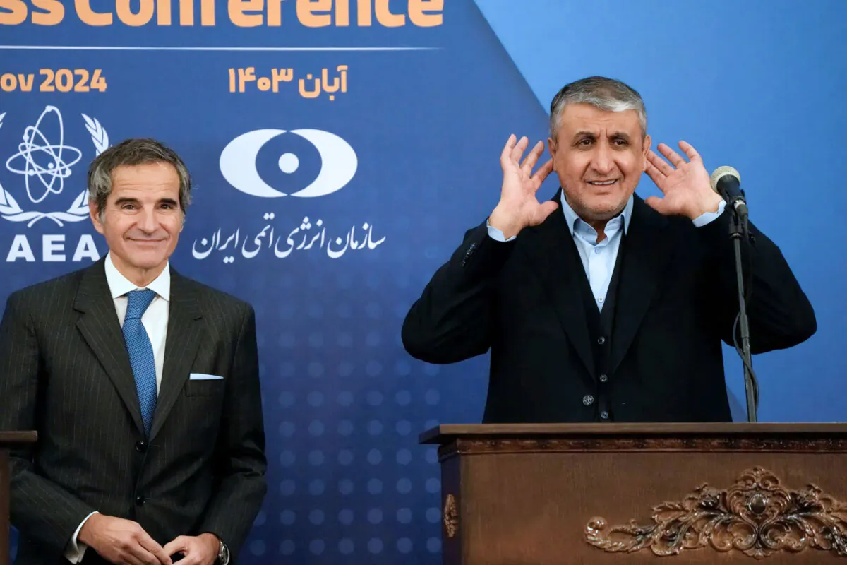 The president of the Atomic Energy Organization of Iran, Mohammad Eslami (R), gestures that he cannot hear a question at a press conference with IAEA chief Rafael Grossi (L) in Tehran, on Nov . 14, 2024 (Vahid Salemi/AP)