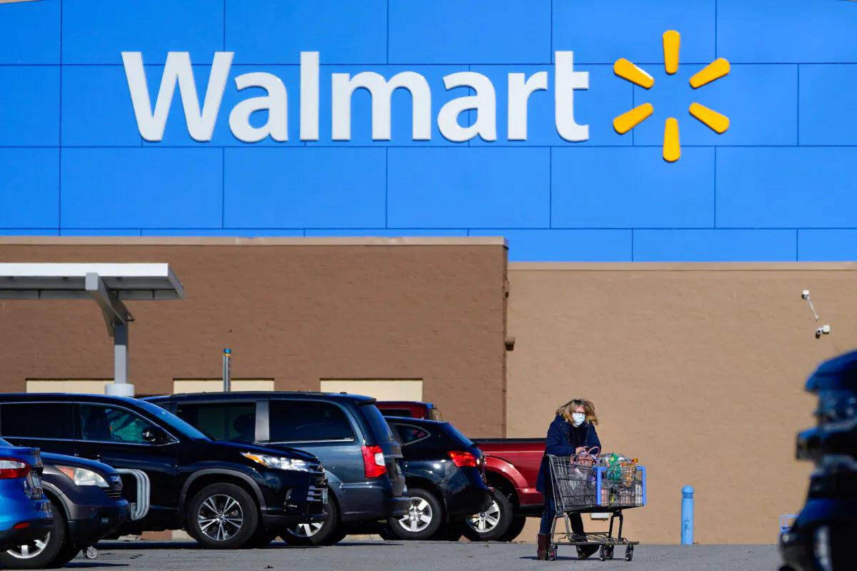 A woman wheels a cart with her purchases out of a Walmart store in Derry, N.H., on Nov. 18, 2020. (Charles Krupa/AP Photo)