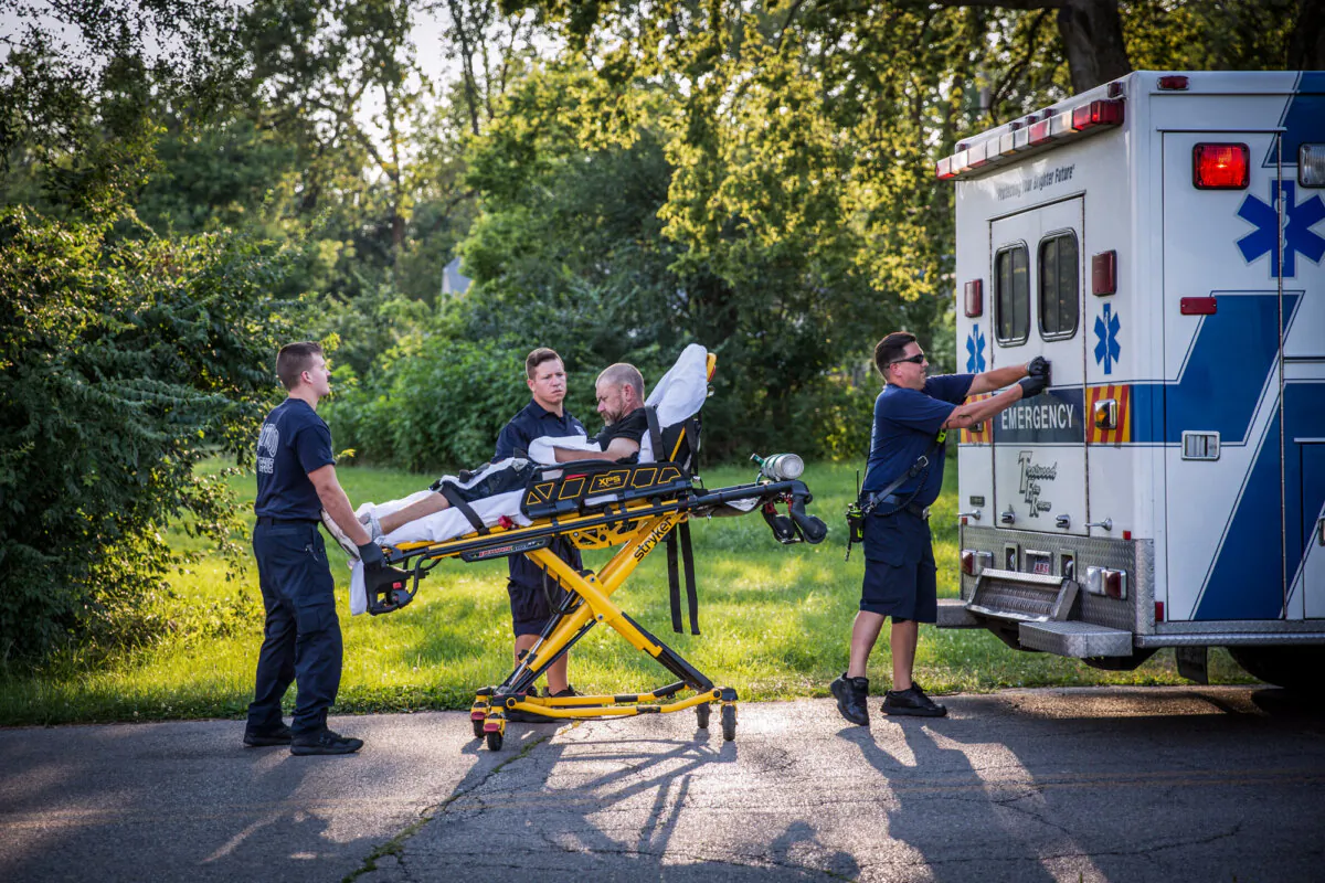 Paramedics attend to a man who is overdosing, in the Drexel neighbourhood of Dayton, Ohio, on Aug. 3, 2017. (The Epoch Times)