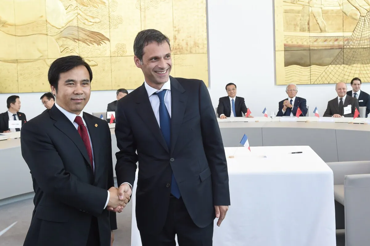 Liu Liange (L), vice-president of Export-Import Bank of China, shakes hands with Rodolphe Saade, vice-president of French container transportation and shipping company CGA-CGM, during a contract signing ceremony in Marseille, France, on July 1, 2015. (Boris Horvat/AFP via Getty Images)