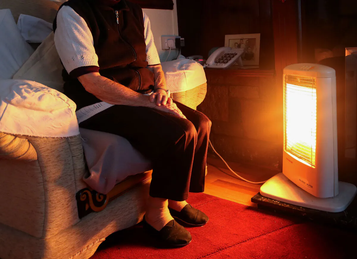 A an elderly lady sitting at home in Liverpool with her electric fire on Nov. 19. 2014. (Peter Byrne/PA)