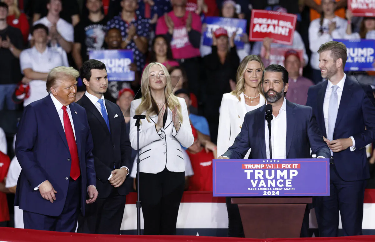 Donald Trump Jr. speaks as former President and Republican presidential candidate Donald Trump (L) listens alongside Tiffany Trump's spouse Michael Boulos (2nd L), Tiffany Trump (3rd L), Co-chair of the Republican National Committee Lara Trump (3rd R), and  Eric Trump (R), during a campaign rally at Van Andel Arena in Grand Rapids, Mich., on Nov. 5, 2024. (Kamil Krzaczynski/AFP via Getty Images)