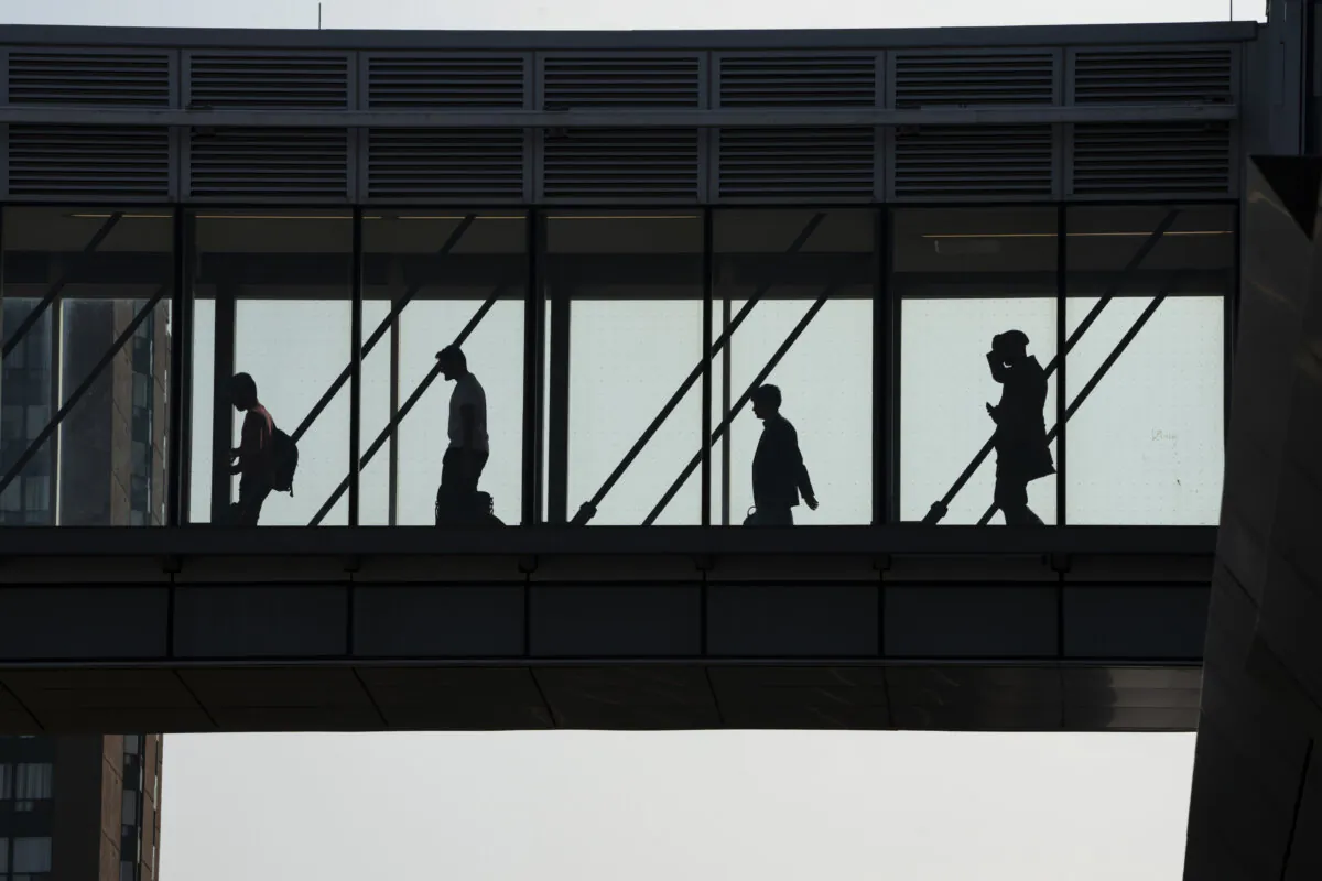 Passengers walk across an overpass at Cooksville GO Station in Mississauga, Ont., on Aug. 26, 2024. (The Canadian Press/Paige Taylor White)
