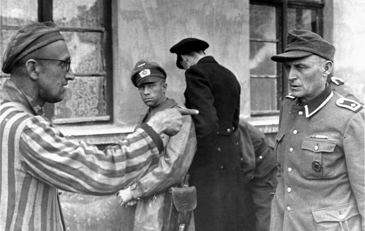 The Czech survivor Zdének Syrovátka, liberated by the 3rd Armored Division of the U.S. First Army, identifies a former SS camp guard who brutally beat prisoners, on April 14, 1945. (Harold M. Roberts, courtesy of Harold Royall/Public Domain)