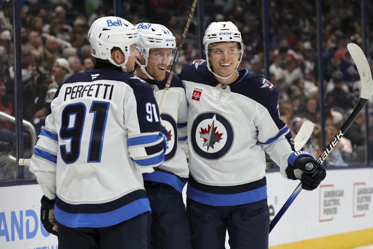 Winnipeg Jets forward Nikolaj Ehlers, center, celebrates his second goal against the Columbus Blue Jackets with teammate forward Cole Perfetti, left, and forward Vladislav Namestnikov during the first period of an NHL hockey game in Columbus, Ohio, on Nov. 1, 2024. (Paul Vernon/AP Photo)
